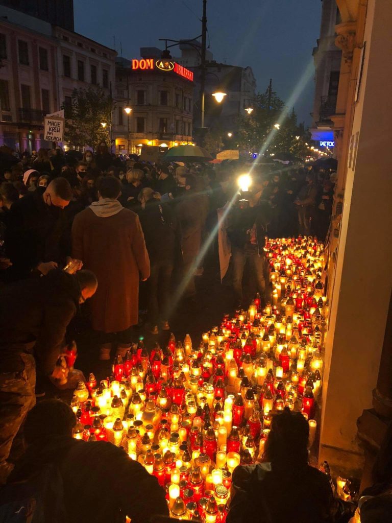 Protesters walk past lanterns at night